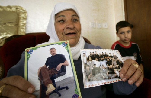 والدة الأسير الفلسطيني محمود جرادات تحمل صورته في جنين أمس (محمد طوروكمان - رويترز)