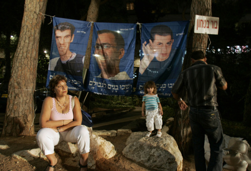 إسرائيليون أمام صور للجنود الثلاثة الأسرى لدى حزب الله و{حماس» خلال تظاهرة في ذكرى العدوان على لبنان في حيفا الأسبوع الماضي (سبستيان شينير - أ ب) 