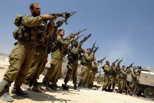 جنود إسرائيليون يفرغون أسلحتهم خارج قطاع غزة أمس (عامير كوهين - رويترز)