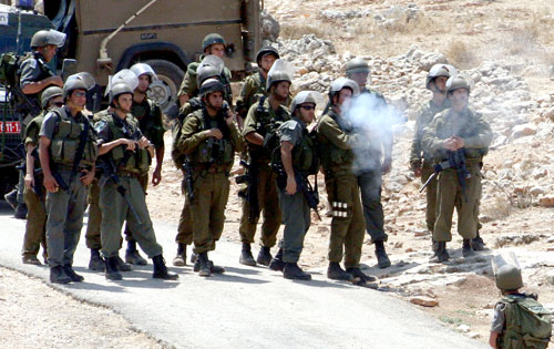 جنود إسرائيليون يطلقون القنابل المسيلة للدموع على متظاهرين في الضفة الغربية أمس (عباس موماني - أ ف ب)