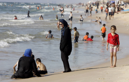 فلسطينيتان بالزي الإسلامي على شاطئ بحر غزة (حاتم موسى ــ أ ب)