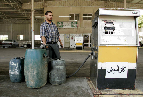 فلسطيني في قطاع غزة يخزّن محروقات تحسّباً لقرار الإغلاق الإسرائيلي (إبراهيم أبو مصطفى - رويترز)
