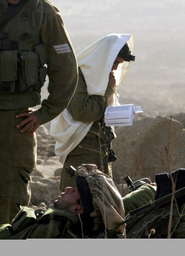 جندي إسرائيلي يصلّي خلال تدريب في الجولان المحتل الأسبوع الماضي (تسافير ابايوف ــ أ ب)