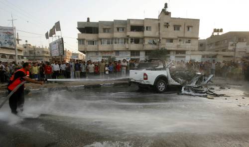 فلسطيني يحاول إخماد النيران في سيارة استهدفتها غارة إسرائيلية في غزة أمس (محمد سالم - رويترز)