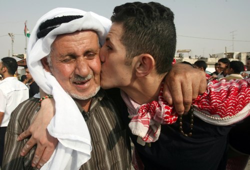 أسير فلسطيني محرّر يقبّل والده في مركز السلطة الفلسطينيّة في رام الله أمس (عمّار عوّاد - رويترز)