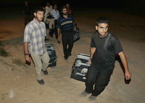 فلسطينيّون كانوا عالقين عند معبر رفح خلال عودتهم إلى قطاع غزّة (إبراهيم أيو مصطفى ــ رويترز)