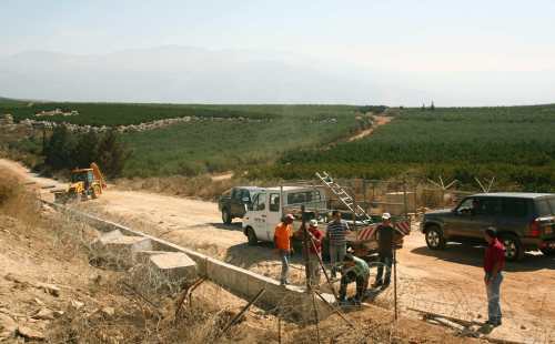 عمال إسرائيليون يصلحون السياج الشائك في منطقة مزارع شبعا المحتلة (أرشيف)