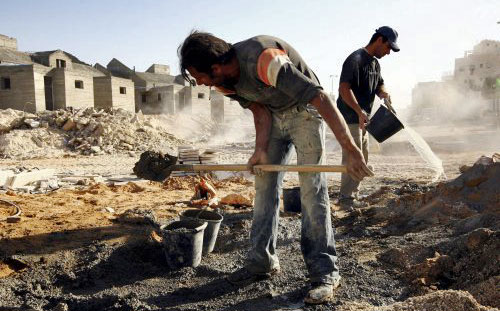 عاملان فلسطينيان يعملان في بناء منازل في مستوطنة معالي أدوميم أول من أمس (ناتي نوشات ـ إي بي أي)