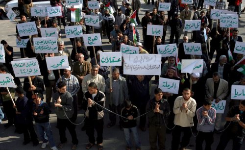 فلسطينيون يحملون لافتات تشير إلى أسماء القرى المحتلة في غزّة أول من أمس (علي علي ـ إي بي أي)
