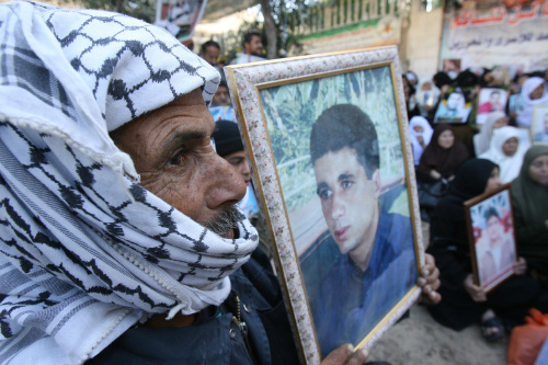 والد أسير فلسطيني يرفع صورته خلال تجمّع تضامني في غزّة أمس (محمّد عبد ـ أ ف ب)