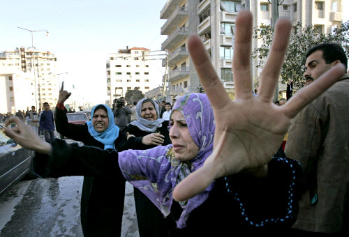 فلسطينيّون يتجمّعون لتفقّد ما خلّفته الغارة الإسرائيليّة على مبنى وزارة الداخليّة في غزّة أمس (حاتم موسى ـ أ ب)