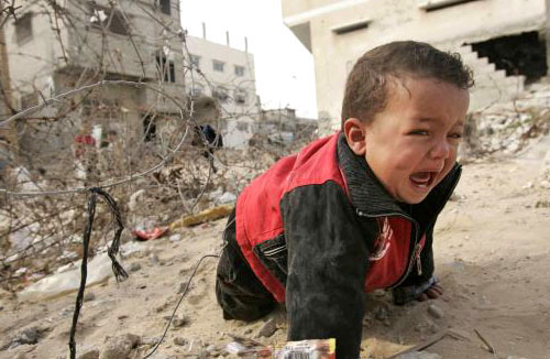 طفل فلسطيني يبكي خارج منزله الذي استهدفته الغارات الإسرائيلية في غزّة أمس (إبراهيم أبو مصطفى ـ رويترز)