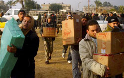 غزّاويّون يحملون المونة بعد عبورهم معبر رفح الحدودي مع مصر أمس (عبد الرحيم خطيب ـ إي بي أي)