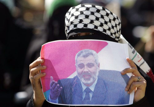 مناصرة لـ«حماس» ترفع صورة إسماعيل هنيّة خلال احتجاج في سيناء أمس (خالد عبد الله ـ رويترز)