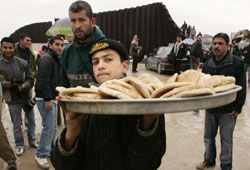فلسطيني يبيع الخبز على المعبر بين غزّة والأراضي المصريّة أمس (محمّد سالم ـ رويترز)