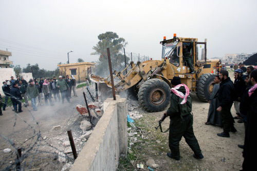 جرّافة فلسطينية تهدم الجدار الحدودي بين غزة ومصر في رفح الشهر الماضي (محمد عبد ـ أ ف ب)