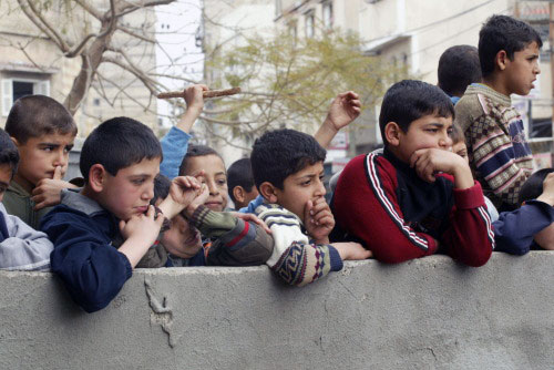 يراقبون تشييع شهداء المجازر الإسرائيليّة في غزة أمس (سعيد خطيب ـ أ ف ب)
