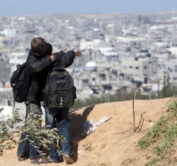 تلميذان فلسطينيّان يراقبان ما بقي من مخيّم جباليا في غزّة أمس (مهدي فدوش ـ أ ف ب)