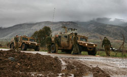جنود إسرائيلّيون قرب مركباتهم العسكريّة في قرية الغجر المقسّمة (غالي تيبون ـ أ ف ب)