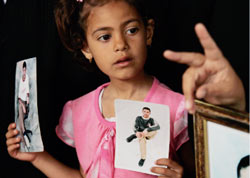 طفلة فلسطينية تحمل صور أسرى فلسطينيين في السجون الإسرائيلية  في غزة أوّل من أمس (حاتم موسى ـ أ ب)