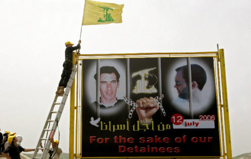 علم حزب الله فوق صورة للأسيرين ريغيف وغولدفاسر في عيتا الشعب (جوزف برّاك ـــ أ ف ب)