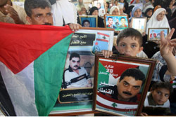 فلسطينيّون يرفعون صور سمير القنطار أمام مقرّ الصليب الأحمر في غزّة أمس (محمد عبد ـ أ ف ب)