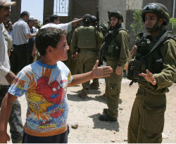 طفل فلسطينيّ يواجه جنديّاً إسرائيليّاً في قرية بورين في الضفّة الغربيّة (جعفر اشتيه ـــ أ ف ب)
