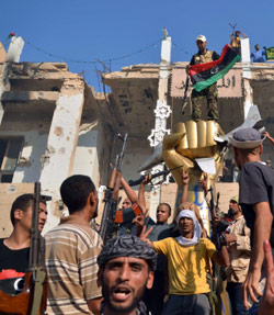 مقاتلون أمام منزل القذافي في باب العزيزية بطرابلس أمس (فلوران مارسيه ــ أ ف ب)