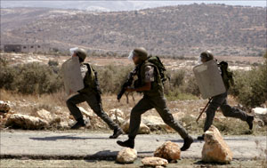 جنود إسرائيليون يتجهون لتفريق تظاهرة احتجاج في قرية بلعين في الضفة الغربية أمس (أ ب)