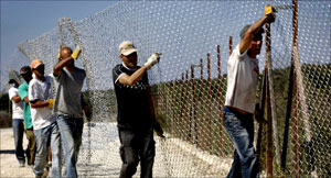 عمال إسرائيليون يصلحون السياج الفاصل عند الحدود مع لبنان أمس (أ ف ب)