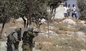 جنود اسرائيليون يوجهون بنادقهم باتجاه متظاهرين فلسطينيين ضد جدار الفاصل  (رويترز)
