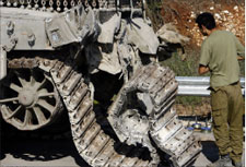 جندي إسرائيلي قرب دبابة معطوبة في جنوب لبنان (أرشيف أ ف ب)