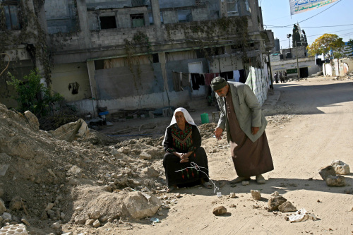 عجوزان فلسطينيان بالقرب من منزلهما المهدّم في بيت حانون أمس (أ ف ب)