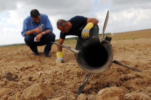 خبيرا متفجّرات إسرائيليّان يتفقّدان موقع سقوط صاروخ قسّام على سديروت قرب قطاع غزّة (أرشيف - رويترز)