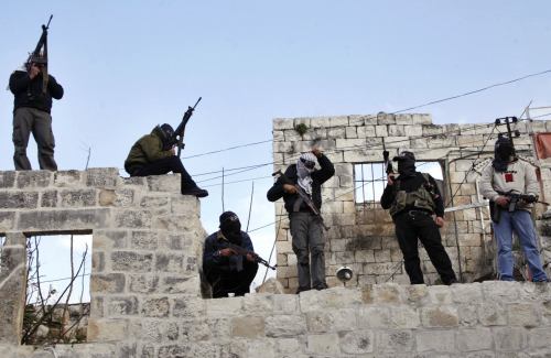 مسلحون من كتائب شهداء الاقصى خلال تظاهرة دعم للرئيس محمود عباس في نابلس أمس (رويترز)
