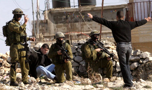 جنود إسرائيليّون يوقفون شقيقين فلسطينيين في بيت لحم في الضّفة الغربيّة أمس (ا ف ب)