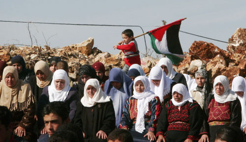 فلسطينيات تصلين قبيل احتجاج ضدّ الجدار الفاصل في الضفّة الغربيّة أمس (أ ب)
