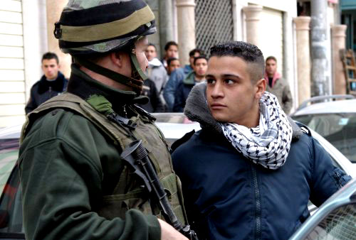 فلسطيني يواجه جنديّاً إسرائيليّاً في الخليل أمس (إي بي أي)