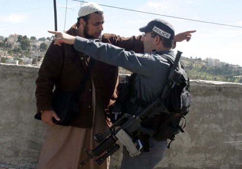 شرطي إسرائيلي ومتظاهر فلسطيني أثناء الاحتجاج شرقي القدس المحتلّة أمس (رويترز)