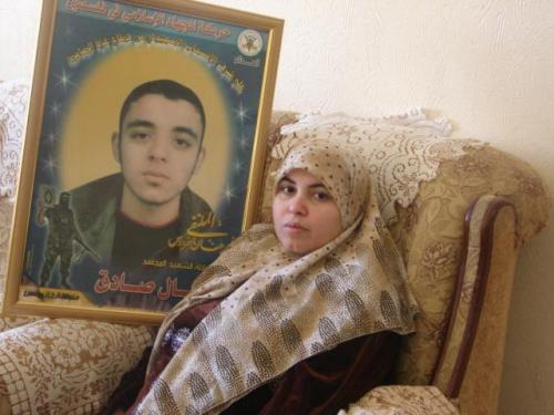 والدة الشهيد نضال صادق أمام صورته في غزّة أمس (الأخبار)