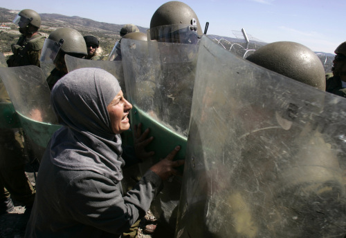 فلسطينيّة تواجه جنود الاحتلال خلال ذكرى «يوم الأرض» في بلعين قرب رام الله أمس (أ ب)
