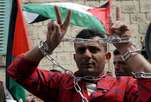 فلسطيني خلال احتجاج في الخليل أمس (عبد حشملون - إي بي أي)