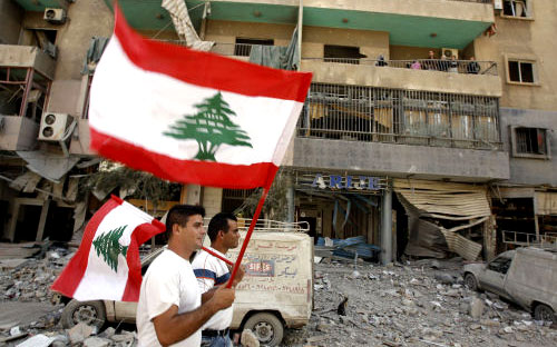 لبنانيّان بين دمار خلّفه عدوان تمّوز في ضاحية بيروت  (أرشيف)