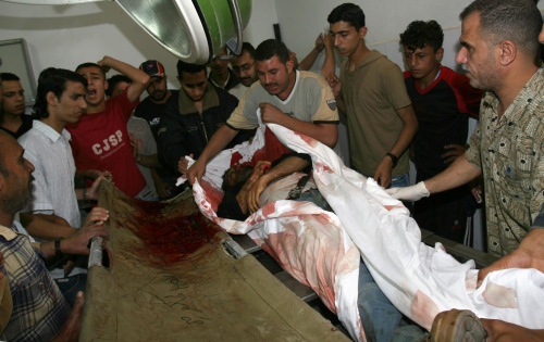 فلسطينيون يكفّنون جثّة أحد عناصر الأمن الفلسطيني في غزّة أمس (سعيد خطيب -