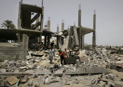 فلسطينيون حول ما تبقّى من مبنى استهدفته القوات الاسرائيلية في غزّة أمس (حاتم موسى - أ ب)