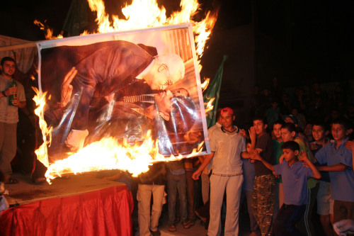 مناصرون لحماس يحرقون صورة محمود عباس وكوندوليزا رايس في غزة أول من أمس (حاتم موسى - أ ب)