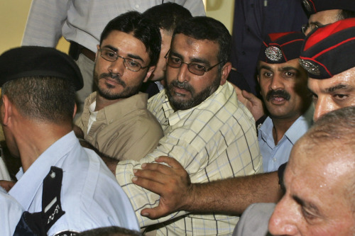 أحد أقارب العجلوني يحاول منع الأمن الأردني من إعادة اعتقاله في عمّان أمس (محمد حامد - رويترز)