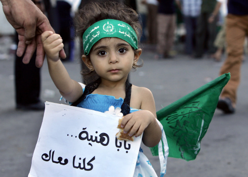 فلسطينية ترافق والدها في تظاهرة لموظفين حكوميين في غزة أول من امس (محمود حمس - أ ف ب)