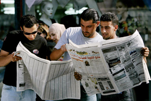 طلاب فلسطينيون يتفقدون نتائجهم في الصحف في رام الله أمس (محمد محيسن - أ ب)