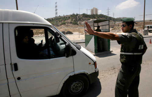 جندي إسرائيلي يوقف سيارة فلسطينية عند أحد حواجز التفتيش في القدس المحتلة أمس (غالي تيبون - أ ف ب)